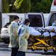 Medics transfer a patient on a stretcher from an ambulance outside of Emergency at Coral Gables Hospital where coronavirus patients are treated in Coral Gables near Miami, on July 30, 2020.